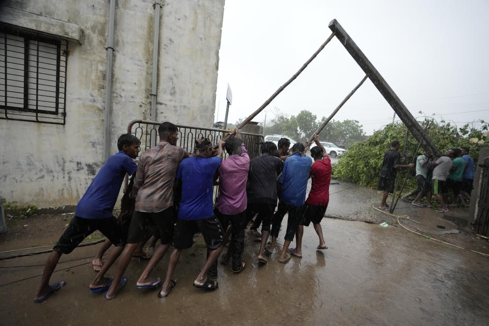 FILE - Workers fix a pole to restore electricity following heavy winds and incessant rains after landfall of cyclone Biparjoy at Mandvi in Kutch district of Western Indian state of Gujarat, Friday, June 16, 2023. A top United Nations official says even though climate change makes disasters such as cyclones, floods and droughts more intense, more frequent and striking more places, fewer people are dying from those catastrophes globally. Thats because of better warning, planning and resilience. (AP Photo/Ajit Solanki, File)