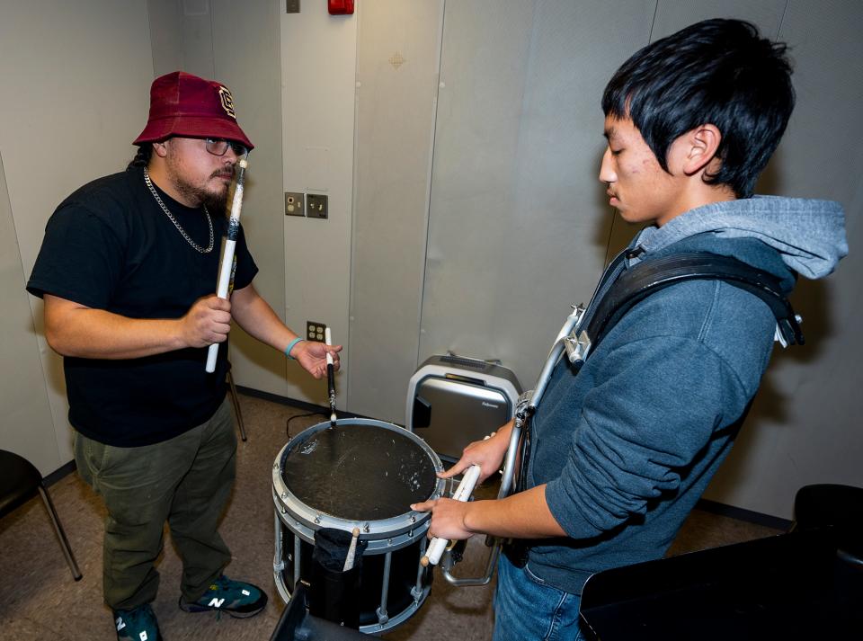 MPS traveling music teacher Jeremy Reyes runs through drills with Riverside University High School student Ckay Yang as they prepare for the Dec. 9 MPS Battle of the Drumlines competition.
