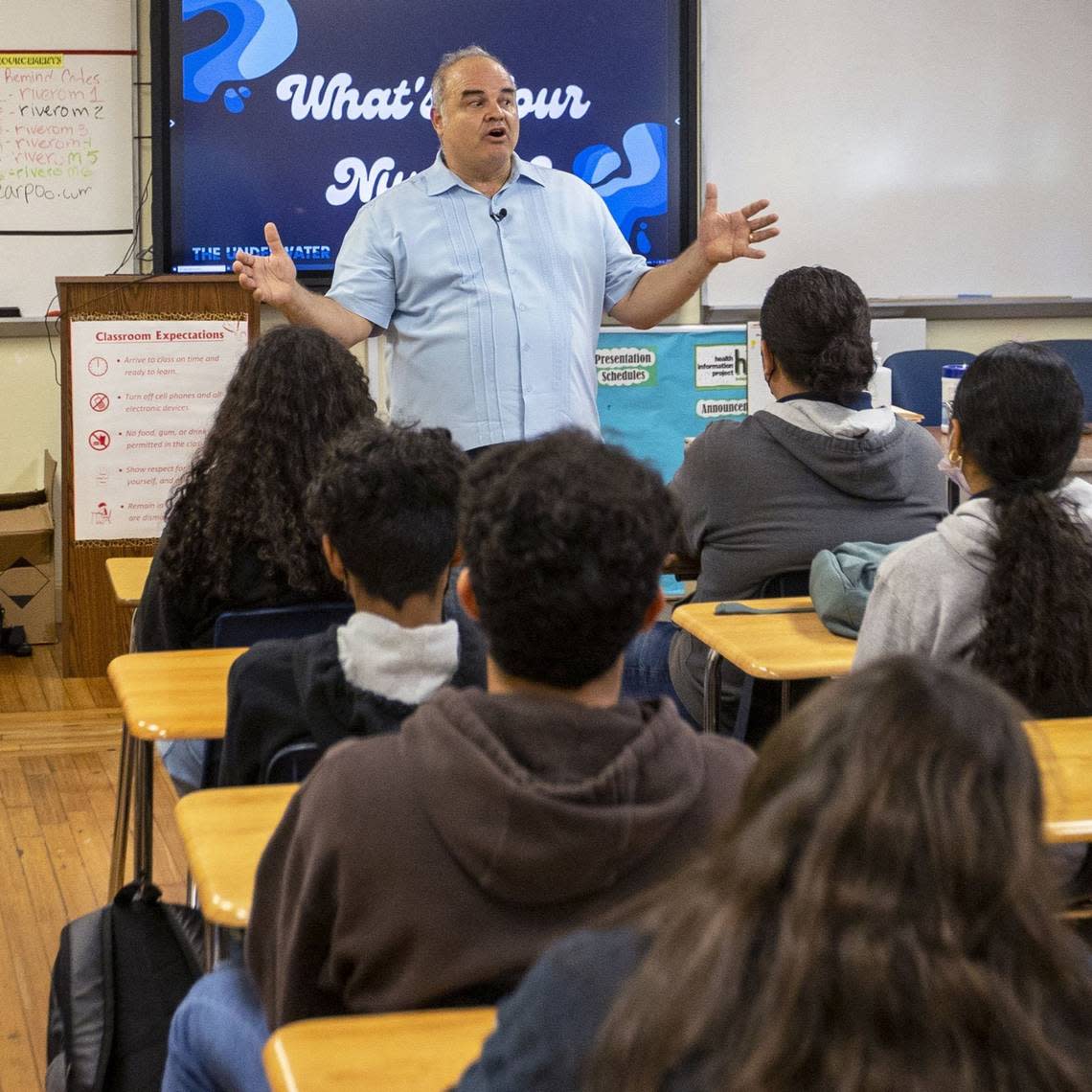 Cuban artist Xavier Cortada speaks to a science class about his eco project dubbed ‘The Underwater,’ which allows high school kids to learn about their homes’ elevation above sea level and then asks them to plant yard signs with said elevation in their own yards in an effort to catalyze conversation and action around the climate crisis. He spoke at Miami Senior High in Miami on April 5, 2022.