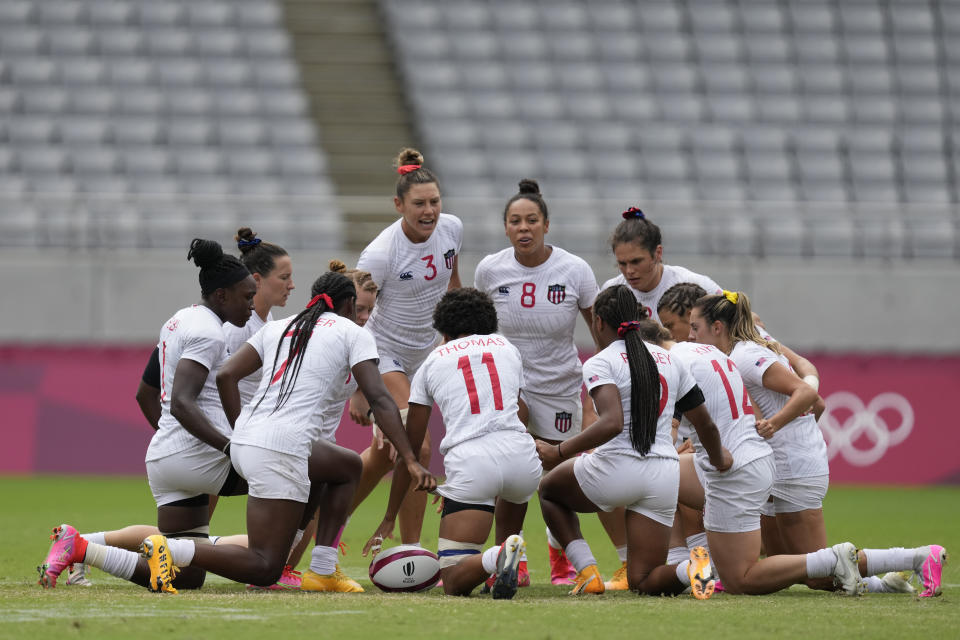 United States players huddle up around Abby Gustaitis of the United States, center left, and Jordan Matyas of the United States, center right, at the start of their women's rugby sevens 5-8 placing match against China at the 2020 Summer Olympics, Saturday, July 31, 2021 in Tokyo, Japan. (AP Photo/Shuji Kajiyama)