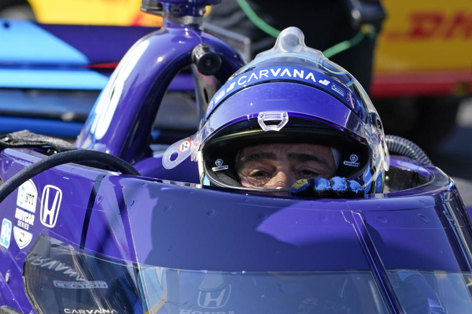 Jimmie Johnson climbs out of his car following practice for the IndyCar auto race at Indianapolis Motor Speedway, Friday, May 14, 2021, in Indianapolis. (AP Photo/Darron Cummings)