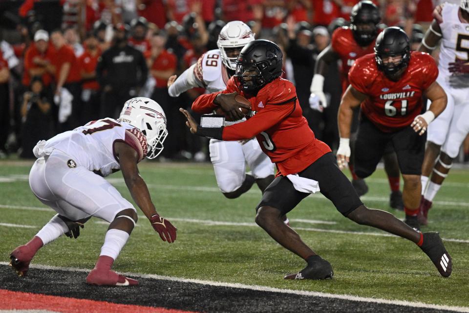 Sep 16, 2022; Louisville, Kentucky, USA;  Louisville Cardinals quarterback Malik Cunningham (3) runs the ball to score a touchdown against Florida State Seminoles defensive back Akeem Dent (27) during the first quarter at Cardinal Stadium. Mandatory Credit: Jamie Rhodes-USA TODAY Sports