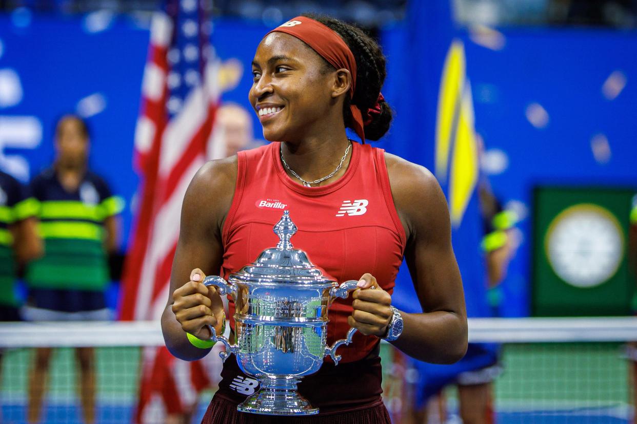 Coco Gauff poes with her trophy after winning the 2023 US Open.