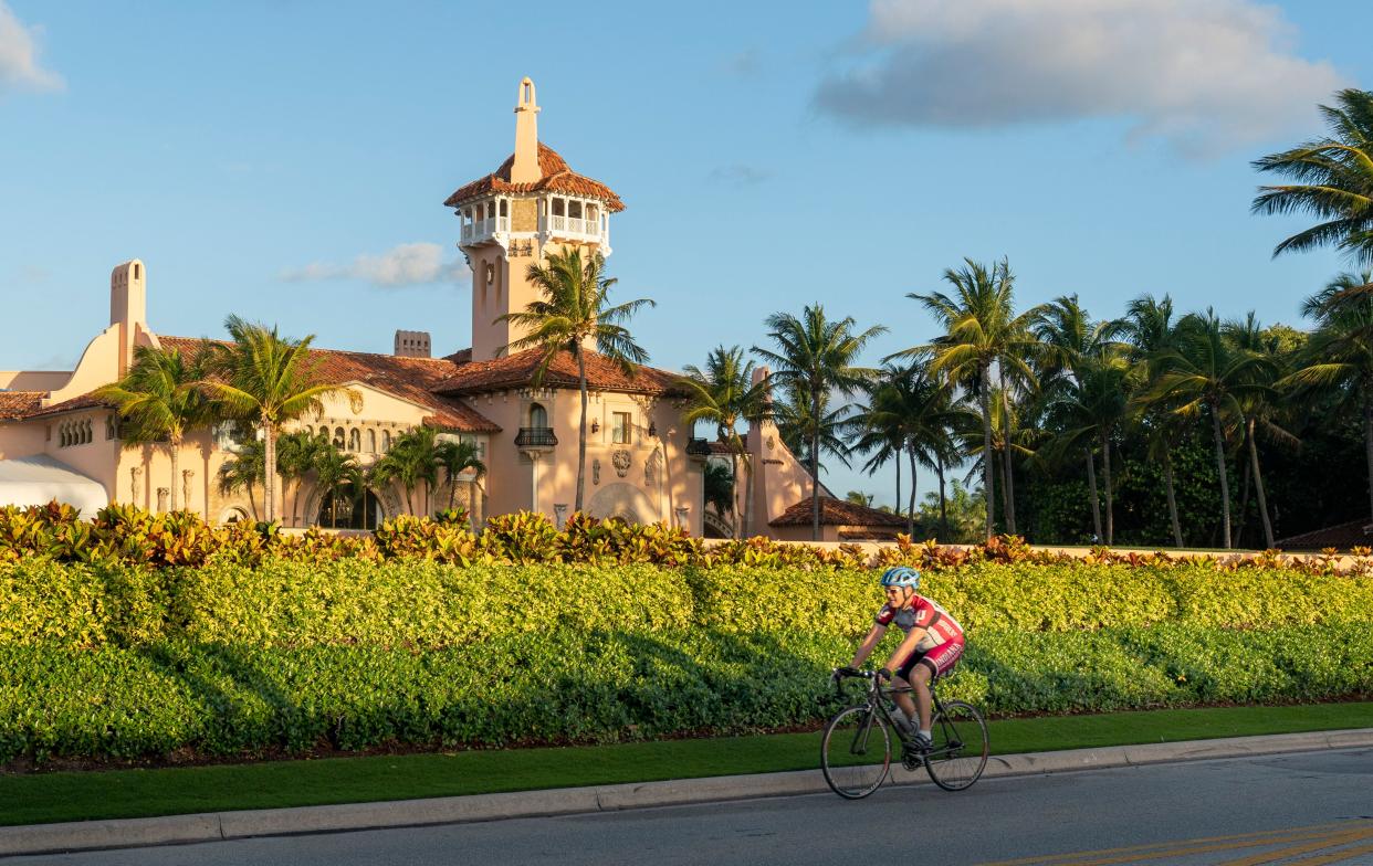 A cyclist pedals by former president Donald Trump's Mar-A-Lago residence in Palm Beach, Florida on March 31, 2023. A New York grand jury voted to indict Trump over hush money payments made to porn star Stormy Daniels ahead of the 2016 election.