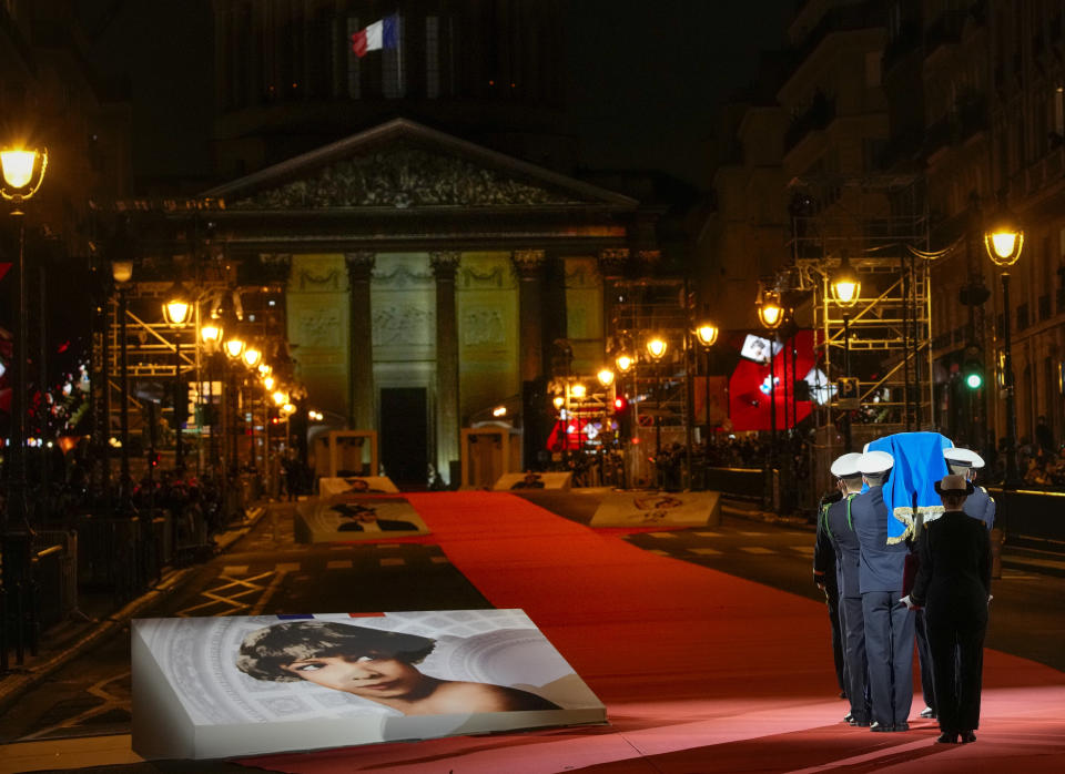 Pictures of Josephine Baker adorn the red carpet as the coffin with soils from the U.S., France and Monaco is carried towards the Pantheon monument in Paris, France, Tuesday, Nov. 30, 2021, where Baker is to symbolically be inducted, becoming the first Black woman to receive France's highest honor. Her body will stay in Monaco at the request of her family. (AP Photo/Christophe Ena)