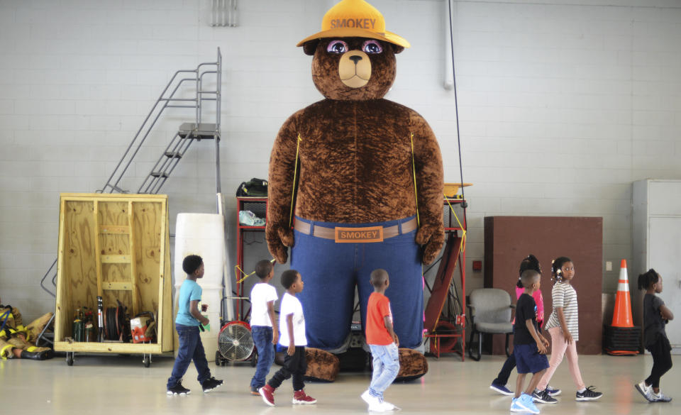 FILE - In this Wednesday, Oct. 11, 2017 file photo, a giant Smokey Bear statue greets children at the Fire Department Open House at Fire Station One in Kinston, N.C. The icon of the longest-running public service campaign in the U.S., was born on Aug. 9, 1944, when the U.S. Forest Service and the Ad Council agreed that a fictional bear would be the symbol for a fire prevention campaign. (Janet S. Carter/Daily Free Press via AP)