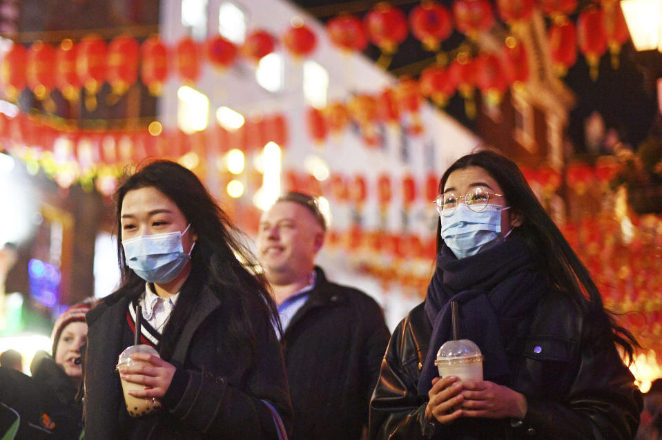 People wearing masks walk in China Town, in London, Saturday, Feb. 1, 2020. China’s death toll from a new virus rose to over 250 on Saturday and a World Health Organization official said other governments need to prepare for“domestic outbreak control” if the disease spreads in their countries. (Victoria Jones/PA via AP)