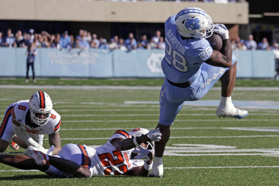 North Carolina running back Omarion Hampton (28) gets tripped up by Syracuse defensive back Jayden Bellamy (23) during the first half of an NCAA college football game against North Carolina, Saturday, Oct. 7, 2023, in Chapel Hill, N.C. (AP Photo/Chris Seward)