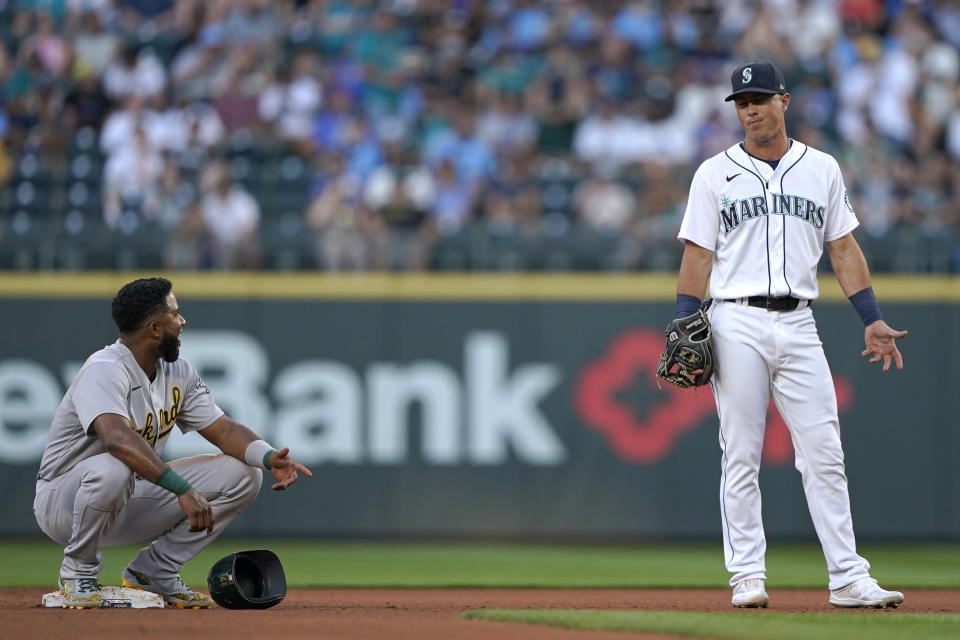 Oakland Athletics' Elvis Andrus, left, talks with Seattle Mariners second baseman Dylan Moore after Andrus reached second during the third inning of a baseball game Saturday, July 24, 2021, in Seattle. (AP Photo/Ted S. Warren)