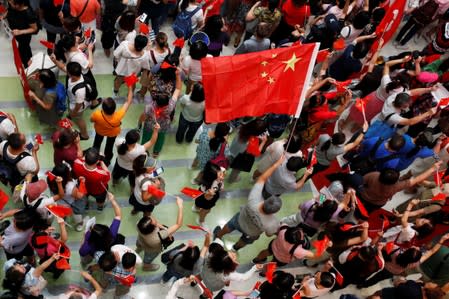 Pro-China demonstrators hold Chinese national flags at Amoy Plaza shopping mall in Kowloon Bay, Hong Kong