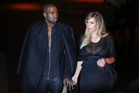U.S. musician Kanye West (L) and companion Kim Kardashian arrive at the Givenchy Spring/Summer 2014 women's ready-to-wear fashion show during Paris Fashion Week September 29, 2013. REUTERS/Charles Platiau