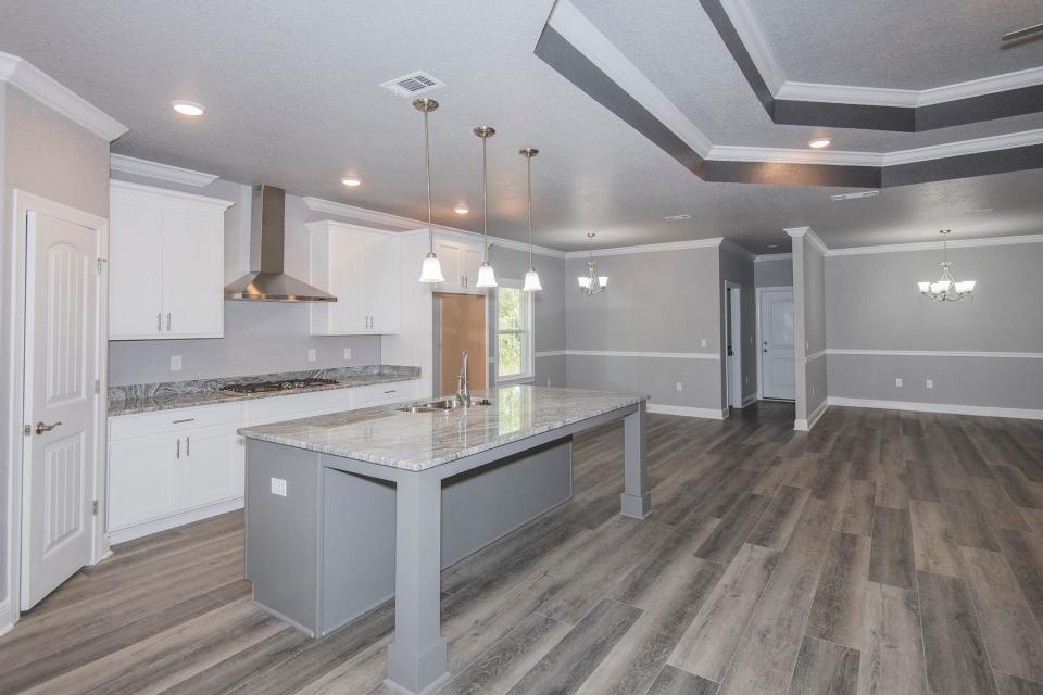 The kitchen of this home at 591 Nowak Road in Cantonment includes bar seating and stainless appliances.