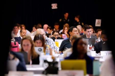 Journalists watch the 2020 Democratic U.S. presidential debate from the spin room in Houston