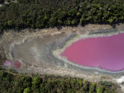 FILE - This Wednesday, Oct. 21, 2020 file photo shows the dry and cracked bed of the Cerro Lagoon due to an extended drought, holding purple water due to untreated waste from a tannery company, in Limpio, Paraguay. An overheating world obliterated weather records in 2020 — an extreme year for hurricanes, wildfires, heat waves, floods, droughts and ice melt — the United Nations’ weather agency reported Wednesday, Dec. 2, 2020. (AP Photo/Jorge Saenz)