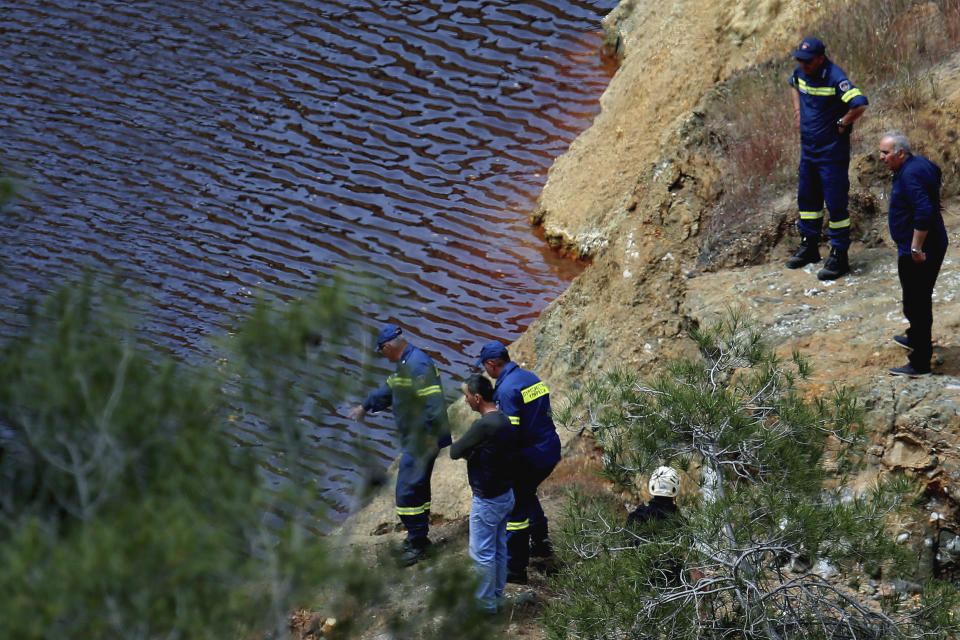 Firefighters and investigators search the man made lake near the village of Mitsero outside of the capital Nicosia, Cyprus, Friday, April 26, 2019. Cyprus police are intensifying a search for the remains of more victims at locations where an army officer who authorities say admitted to killing five women and two girls had dumped their bodies. (AP Photo/Petros Karadjias)