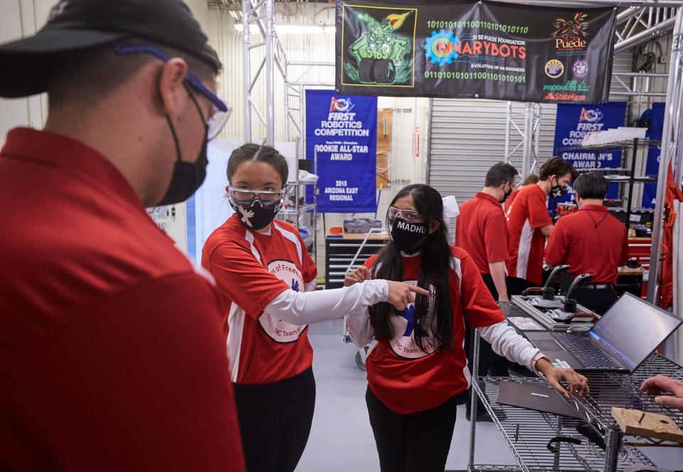 Liz Seaton (center) and Madhumitha Thumati (right) discuss how to change the code of Red Bull with Juan Palomino after the robot moved too far in a test at Si Se Puede Foundation STEM Center in Chandler on April 13, 2022.