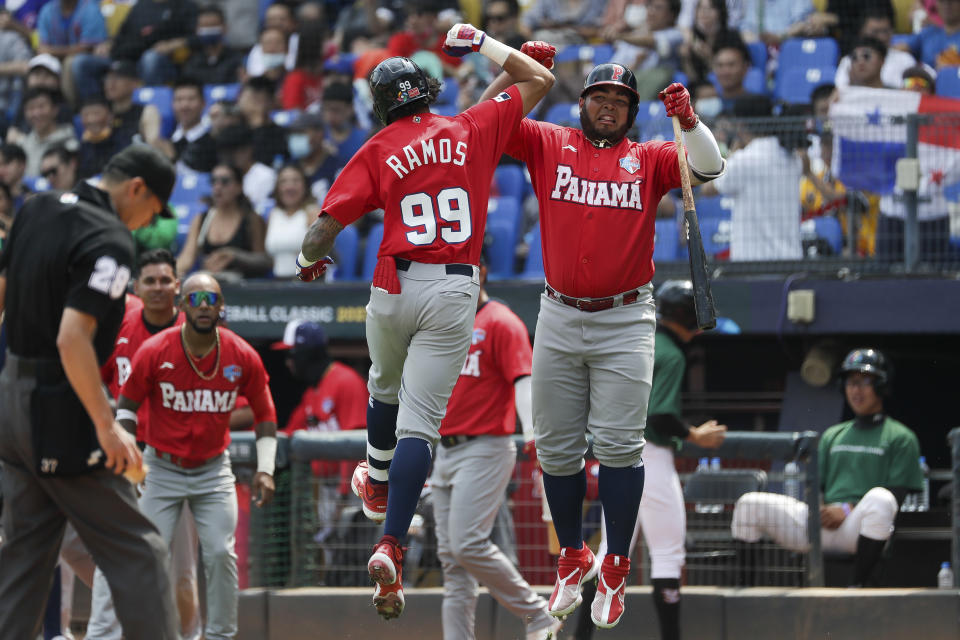 José Ramos (izquierda), de Panamá, salta para celebrar con un compañero tras anotar una carrera en el segundo inning de un juego del Clásico Mundial contra Italia, en Taichung, Taiwán, el 11 de marzo de 2023. (AP Foto/I-Hwa Cheng)