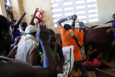 People fight as they try to get food during a special distribution in a church after Hurricane Matthew passed through Jeremie, Haiti, October 11, 2016. REUTERS/Carlos Garcia Rawlins