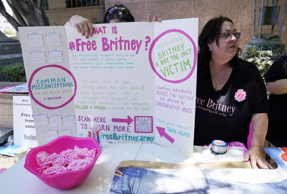 Britney Spears supporters Jan Simmons, right, of Detroit, and her daughter Leanne set up a table outside a court hearing concerning the pop singer's conservatorship at the Stanley Mosk Courthouse, Wednesday, June 23, 2021, in Los Angeles. (AP Photo/Chris Pizzello)