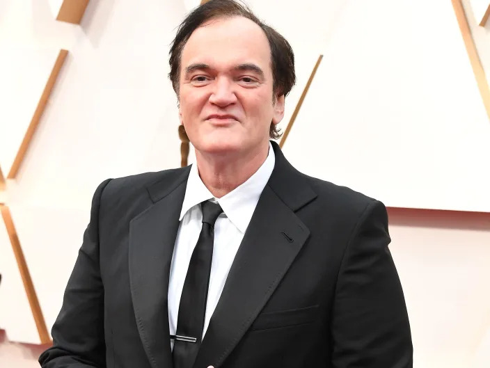 Quentin Tarantino in a black suit with black tie
