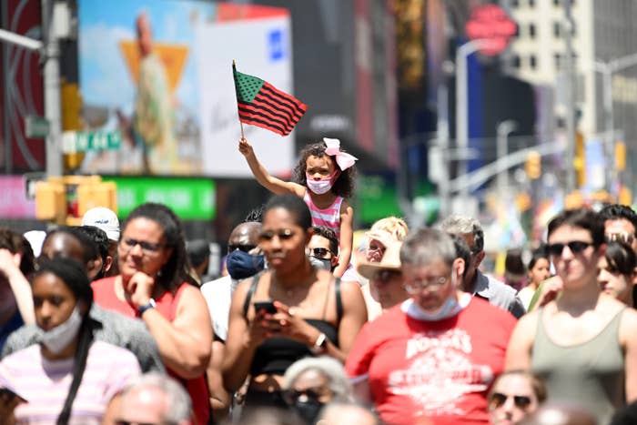 A young girl waves an African American flag during the Broadway Celebrates Juneteenth in Times Square on June 19 in New York City.