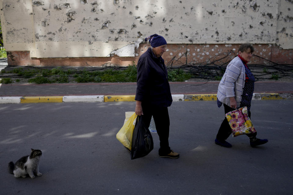 Residents walk toward their homes, buildings ruined by shelling in Irpin, outskirts of Kyiv, Ukraine, Tuesday, May 24, 2022. (AP Photo/Natacha Pisarenko)