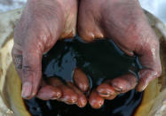 An employee demonstrates a sample of crude oil in the Yarakta Oil Field, owned by Irkutsk Oil Company (INK), in Irkutsk Region, Russia in this picture illustration taken March 11, 2019. REUTERS/Vasily Fedosenko/Illustration