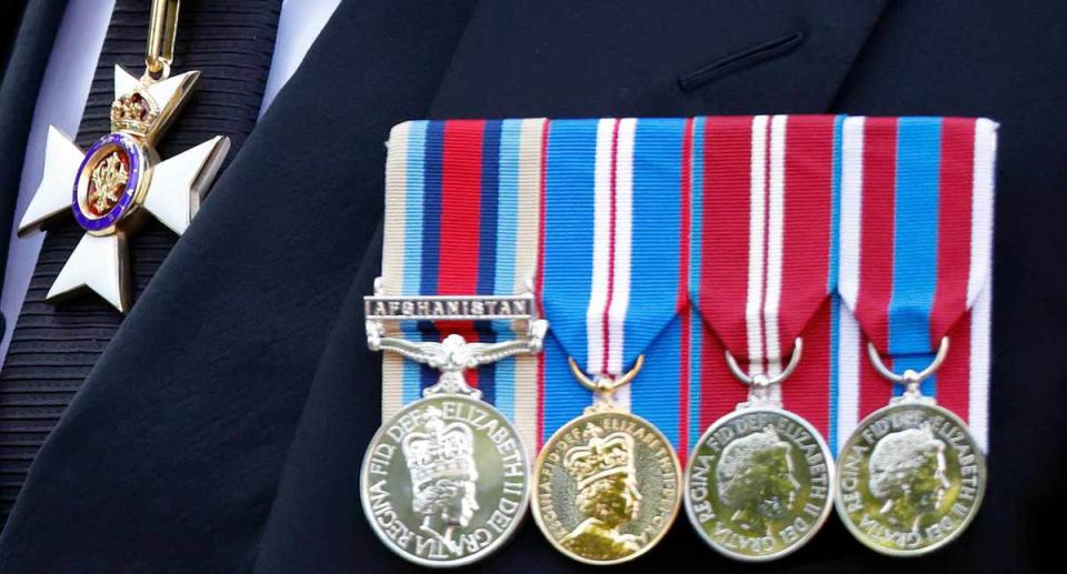 Prince Harry, the Duke of Sussex, wears his medals over his suit - the Knight Commander of the Royal Victorian Order (KCVO), the Operational Service Medal for Afghanistan, and the Queen's Golden Jubilee Medal, the Queen's Daimond Jubilee Medal and the Queen's Platinum Jubilee Medal. 