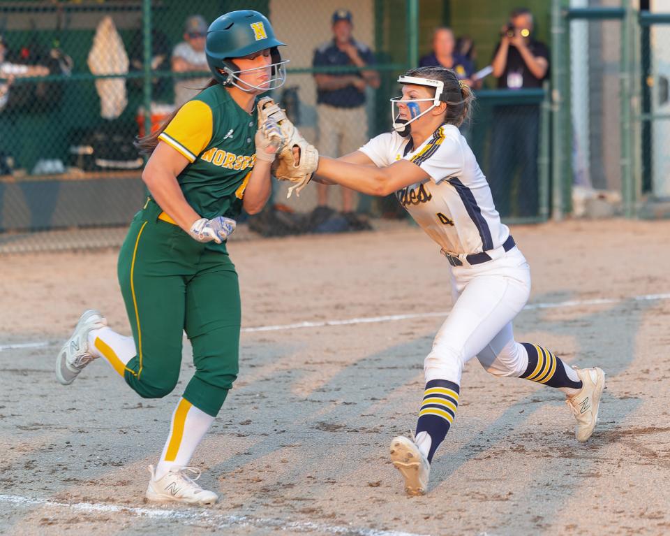 Hartland's Kate McIntyre tags out Grosse Pointe North's Julia Liagre, whose bunt put runners on second and third in the sixth inning, during the Eagles' 3-0 quarterfinal victory Wednesday, June 14, 2023 at Wayne State University.