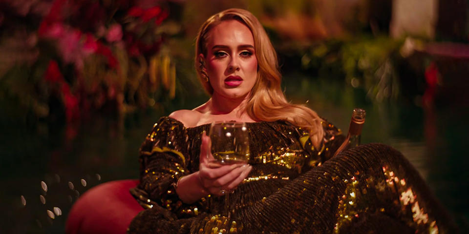 Adele floats on a river while drinking wine in the video for 
