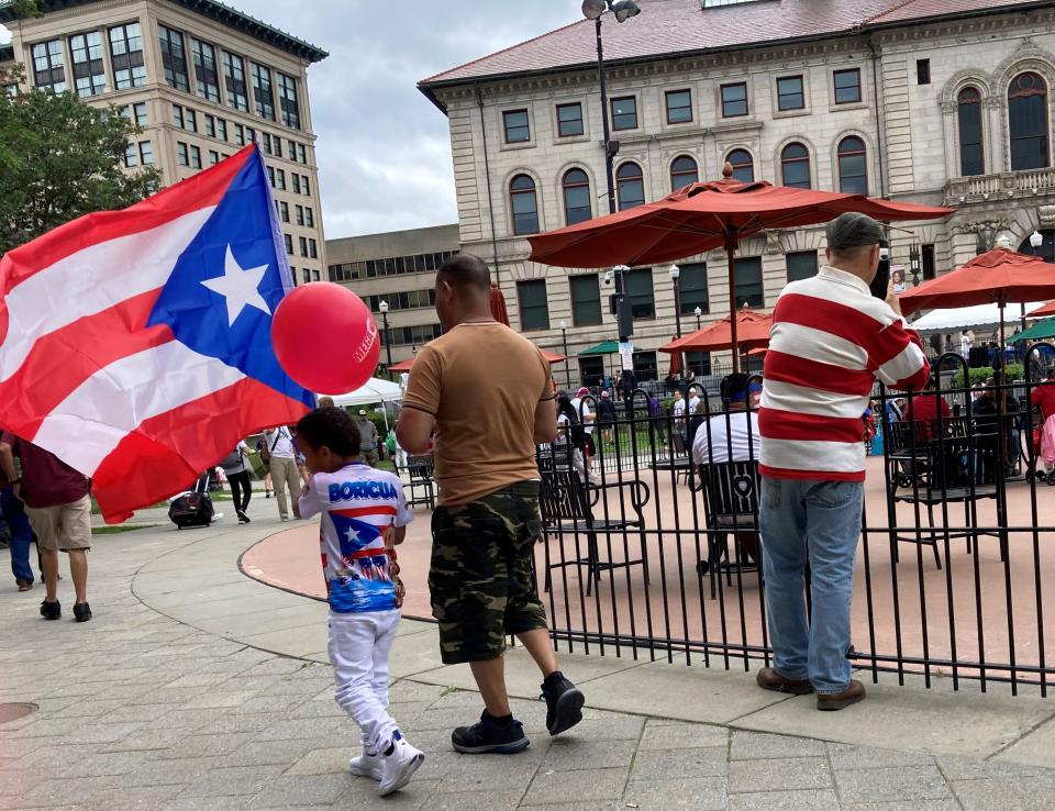 Jobson Tineo and his father, José, parade their pride and the Puerto Rican flag Saturday at the Latin American Festival in Worcester.