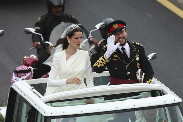 El príncipe Hussein y la saudita Rajqa Alseif saludan a la gente a su paso hacia el lugar de la ceremonia