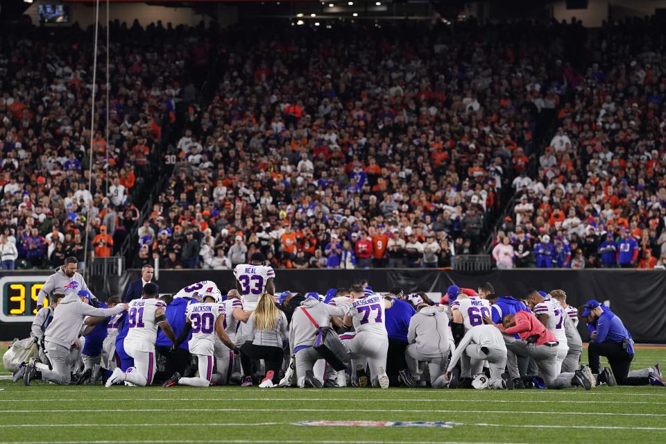 Bills players huddle and pray after teammate Damar Hamlin collapsed on the field after making a tackle against the Bengals on Monday night.