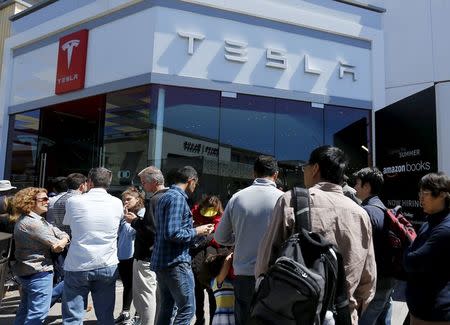 People wait in line at a Tesla Motors dealership to place deposits on the electric car company's mid-priced Model 3 in La Jolla, California, March 31, 2016. REUTERS/Mike Blake