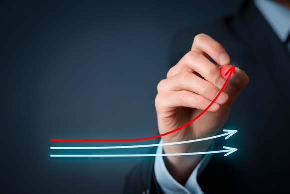 Man drawing a red line that moves upwards above two other lines.
