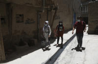 Health workers go door to door during a polio vaccination campaign in the old part of Kabul, Afghanistan, Tuesday, June 15, 2021. Gunmen on Tuesday targeted members of polio teams in eastern Afghanistan, killing some staffers, officials said. (AP Photo/Rahmat Gul)