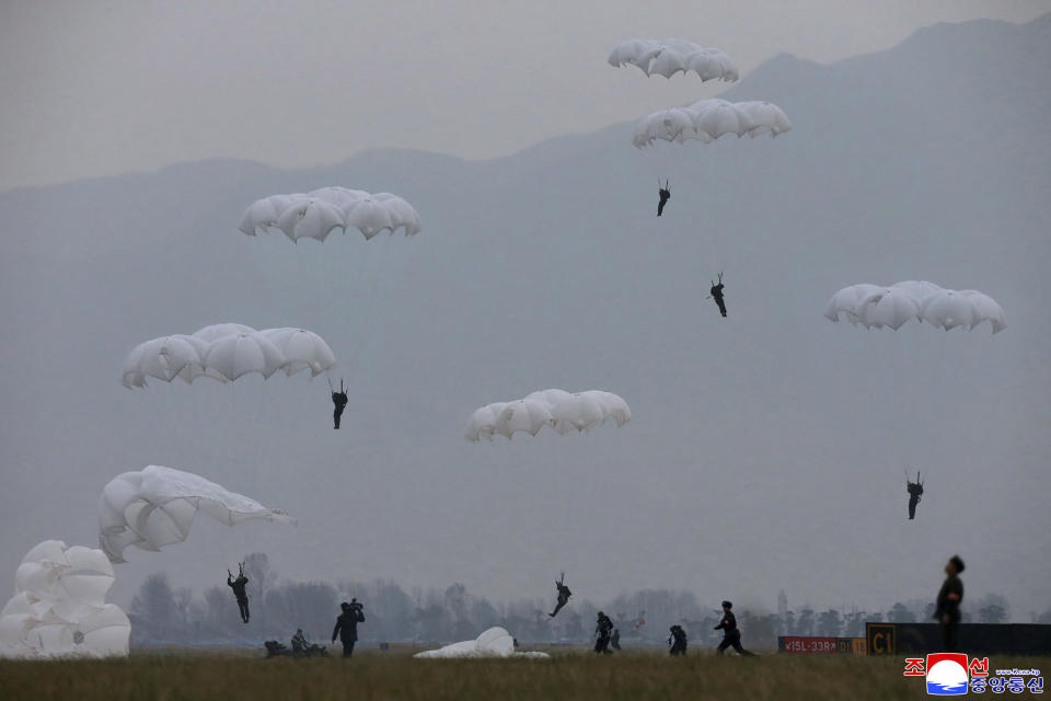 This undated photo provided on Monday, Nov. 18, 2019, by the North Korean government shows a parachuting drill of military sharpshooters at an unknown location in North Korea. North Korean leader Kim Jong Un supervised a parachuting drill of military sharpshooters and vowed to build an “invincible army,” displaying more defiance even as the United States and South Korea called off their own exercises to create space for nuclear diplomacy. Independent journalists were not given access to cover the event depicted in this image distributed by the North Korean government. The content of this image is as provided and cannot be independently verified. Korean language watermark on image as provided by source reads: "KCNA" which is the abbreviation for Korean Central News Agency. (Korean Central News Agency/Korea News Service via AP)