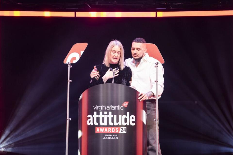 Esther Ghey on stage giving a speech standing next to Jaxon Feeley