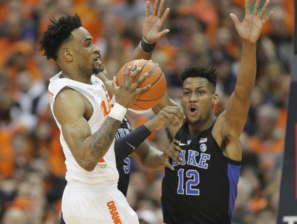 Syracuse's Oshea Brissett, left, passes under pressure from Duke's Javin Delaurier, right, during the first half of an NCAA college basketball game in Syracuse, N.Y., Saturday, Feb. 23, 2019. (AP Photo/Nick Lisi)