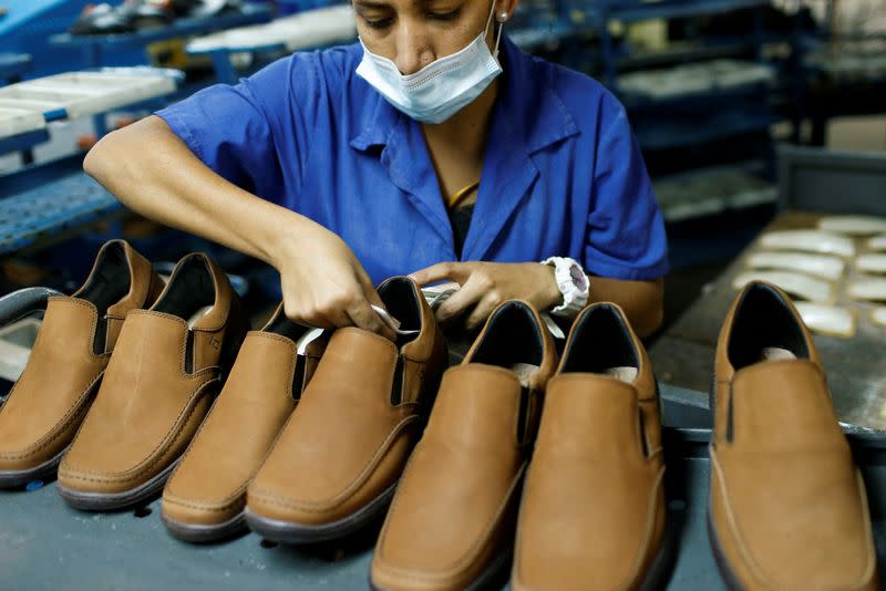 Un trabajador pone etiquetas de fábrica en la fábrica de calzado Full Time, en Caracas