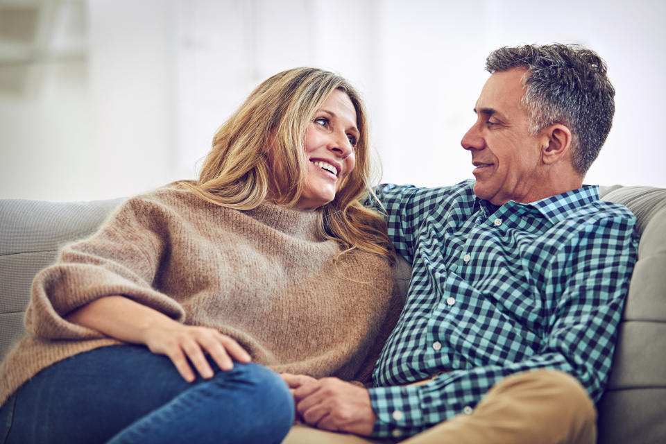 Shot of a mature couple talking on the sofa at home