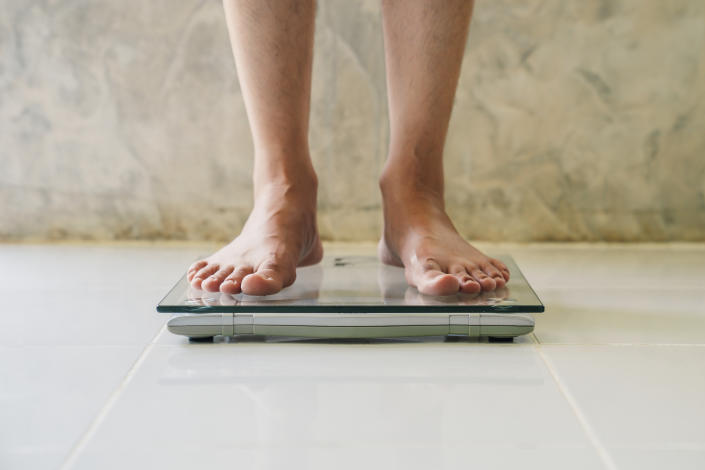 Male on weight scale on floor background, Diet concept.

