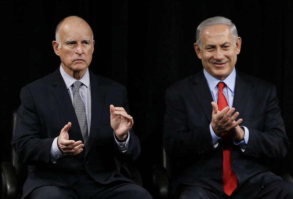 California Gov. Jerry Brown, left, and Israeli Prime Minister Benjamin Netanyahu, right, applaud former U.S. Secretary of State George Shultz before the signing of an agreement to expand cooperation at the Computer History Museum Wednesday, March 5, 2014, in Mountain View, Calif. Netanyahu is visiting California, trading a focus on the geopolitics of the Middle East for a Hollywood screening and visits with Silicon Valley tech entrepreneurs.(AP Photo/Eric Risberg)