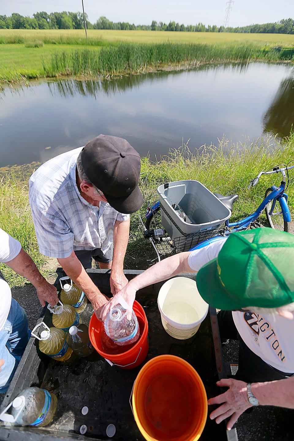 Green Acres resident Sonny McLaurin fetches water from a pond on Thursday. The trailer park's generator wasn't working after storms knocked out power this week, and residents were without running water for three days before the park rented a generator. TOM E. PUSKAR/ASHLAND TIMES-GAZETTE