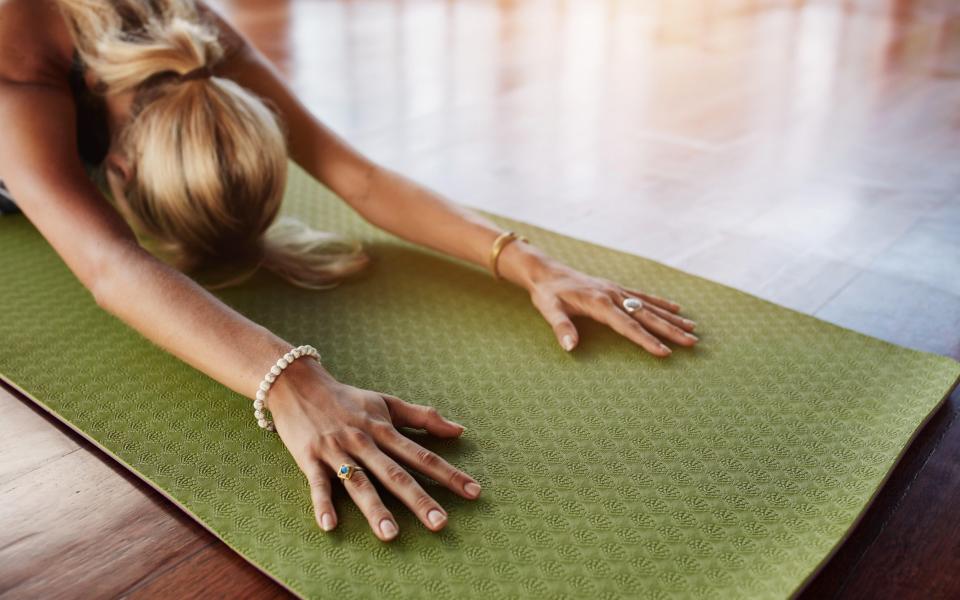 Female doing stretching workout on exercise mat. Woman doing balasana yoga at gym, with focus on hands. - Alamy Stock Photo