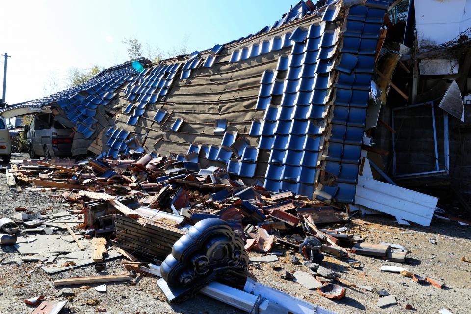 A house collapses after the Magnitude 7.3 strong earthquake hits Northern Japan on 17 March (The Asahi Shimbun via Getty Imag)