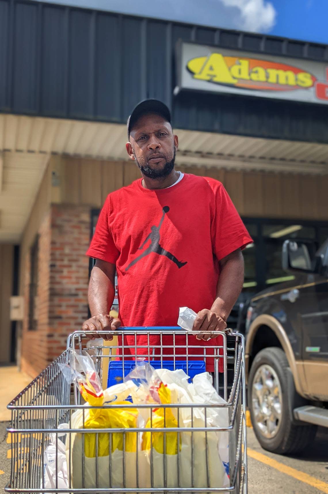 Mark Bridges pushes his shopping cart full of groceries out of Adams Food Center. Bridges got a $50 grocery voucher from 34N22, a pro-Herschel Walker PAC. Walker is the Republican nominee for U.S. Senate. 07/28/2022