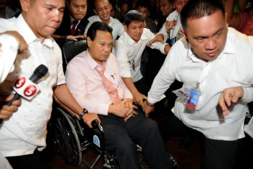 Philippines Chief Justice Renato Corona (in wheelhair) is escorted by security personnel as he leaves the Senate after testifying at his impeachment trial in Manila. The Philippines' top judge denied he was a crook as he testified then dramatically walked out at his own trial Tuesday, denouncing his impeachment as a personal vendetta by President Benigno Aquino