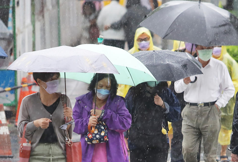 近期受滯留鋒影響，連日皆有陣陣雨勢，路人紛紛撐起雨傘防止淋濕。（季志翔攝）