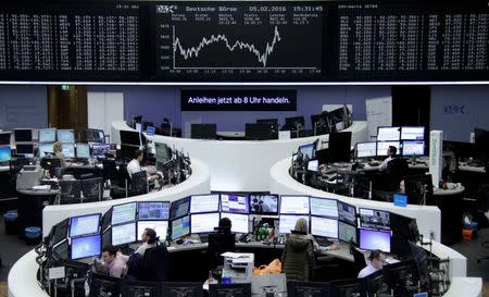 Traders work at their desks in front of the German share price index, DAX board, at the stock exchange in Frankfurt, Germany, February 5, 2016. REUTERS/Staff